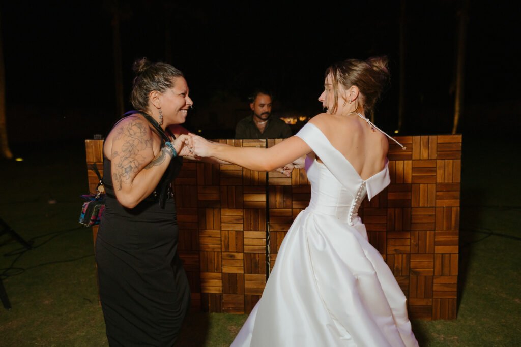 Joe dancing with the bride in front of the DJ booth late at night