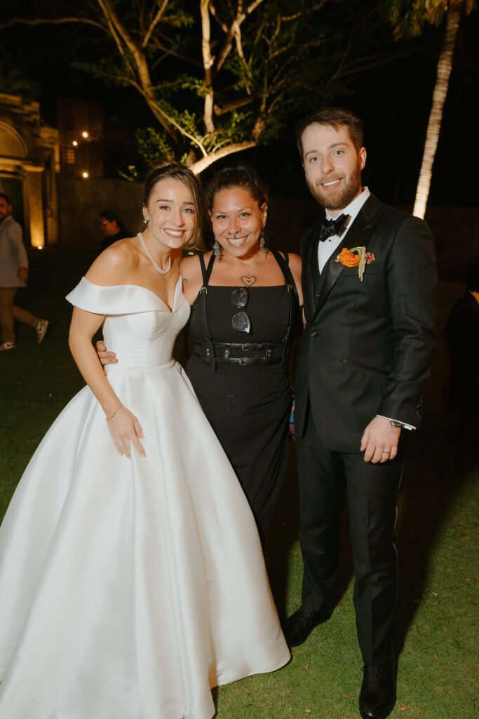 Joe standing between the bride and groom, all three laughing