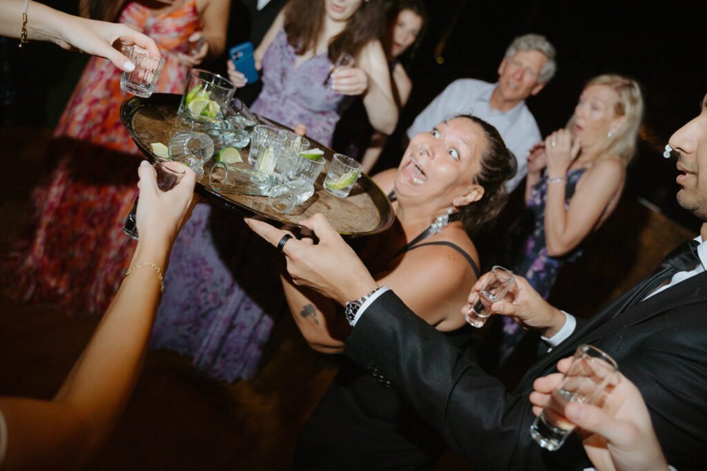 Joe carrying a tray of tequila and lime through the party, laughing with guests