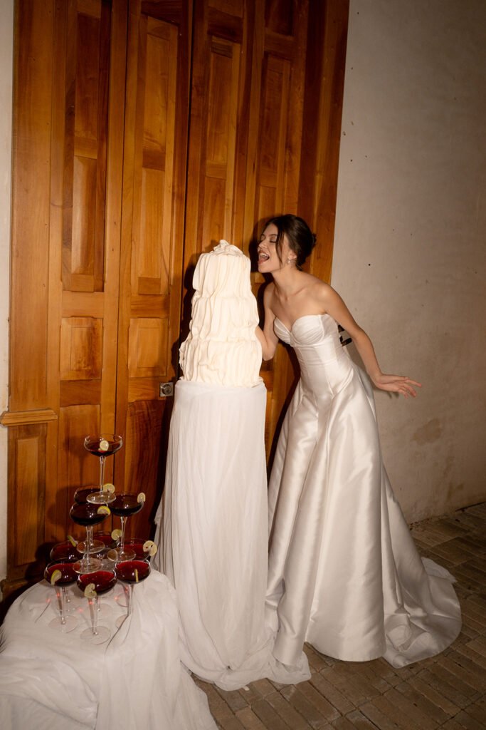 The bride laughing beside the cake and a tower of coupes