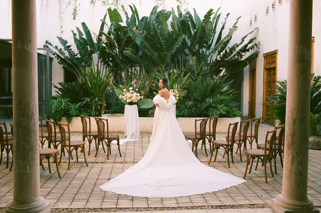 The bride in the courtyard, her train spread across the tiled floor before the ceremony