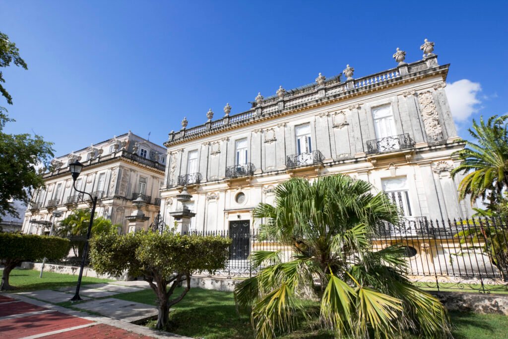 A grand colonial mansion on Paseo de Montejo, Mérida, under palms and a bright sky